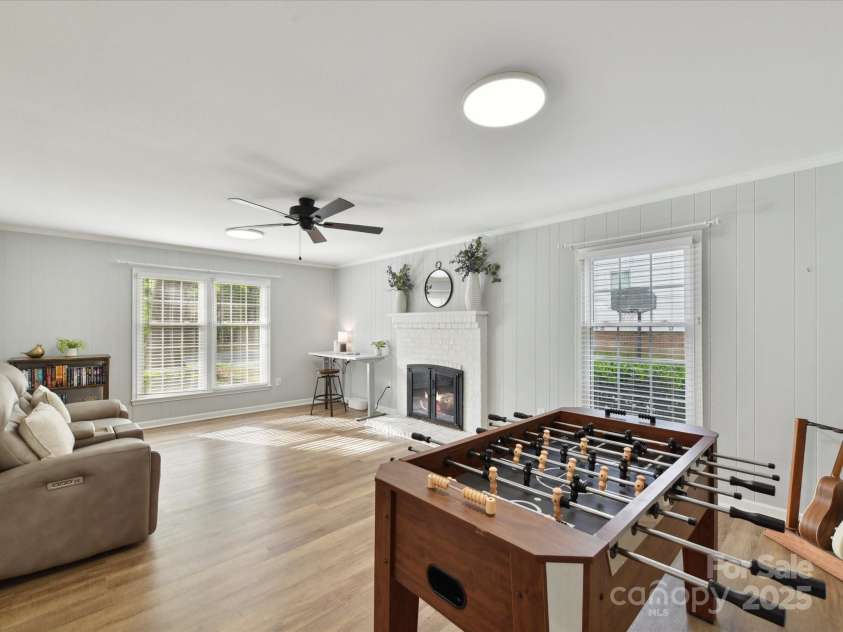 2315 Lawton Bluff Road, Charlotte, NC 28226.  MLS# CAR4255535, YatesRealty ID 19671. Spacious den off of entry that features a barn door, updated lighting, lots of windows & a wood-burning fireplace.