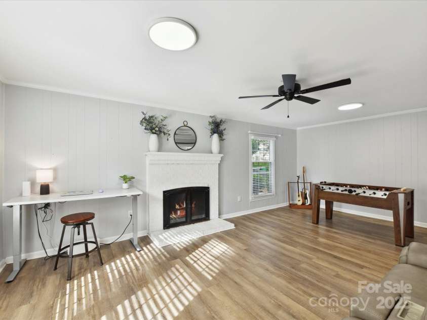 2315 Lawton Bluff Road, Charlotte, NC 28226.  MLS# CAR4255535, YatesRealty ID 19671. Spacious den off of entry that features a barn door, updated lighting, lots of windows & a wood-burning fireplace.