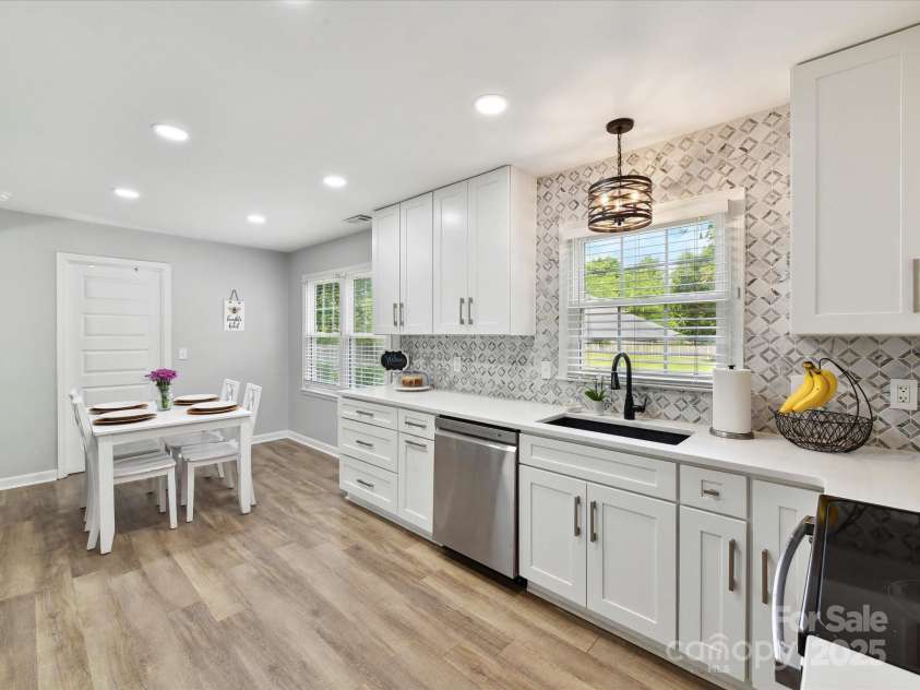 2315 Lawton Bluff Road, Charlotte, NC 28226.  MLS# CAR4255535, YatesRealty ID 19671. Stunning kitchen features white cabinetry, quartz ctops, ss appli, updated lighting & a beautiful tile backsplash!