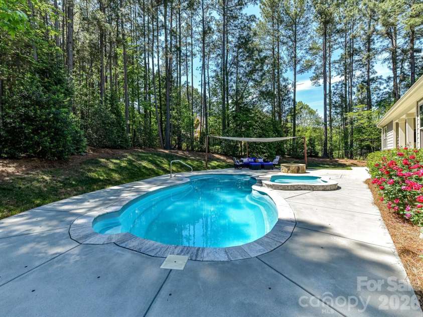 205 Streamwood Road, Troutman, NC 28166.  MLS# CAR4378738, YatesRealty ID 19708. Private backyard oasis featuring a sparkling in-ground pool, tanning ledge, expansive patio, fire pit, and wooded surroundings designed for relaxing and entertaining year-round.
