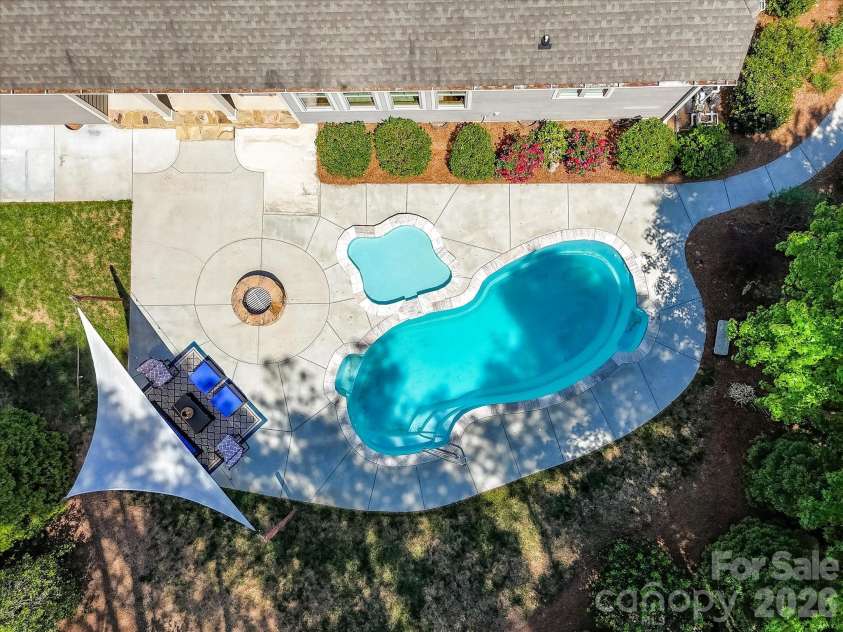 205 Streamwood Road, Troutman, NC 28166.  MLS# CAR4378738, YatesRealty ID 19708. Private backyard oasis featuring a sparkling in-ground pool, tanning ledge, expansive patio, fire pit, and wooded surroundings designed for relaxing and entertaining year-round.