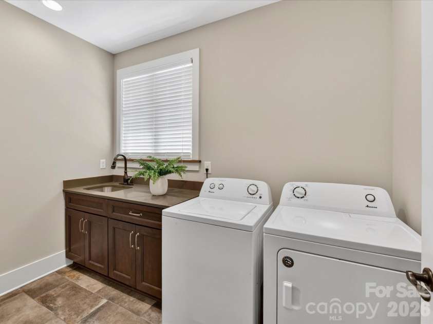 205 Streamwood Road, Troutman, NC 28166.  MLS# CAR4378738, YatesRealty ID 19708. Spacious laundry room features built-in cabinetry, utility sink, and ample workspace for added convenience and organization.