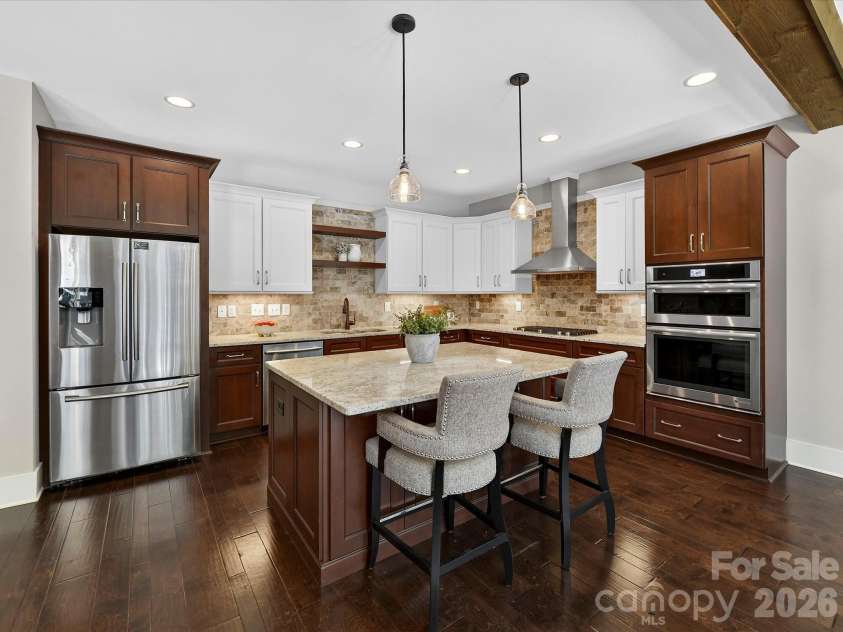 205 Streamwood Road, Troutman, NC 28166.  MLS# CAR4378738, YatesRealty ID 19708. Thoughtfully designed gourmet kitchen offers expansive prep space, granite counters, stainless steel appliances, custom cabinetry, designer lighting, a gas cooktop with stainless hood, and seamless flow into the dining 