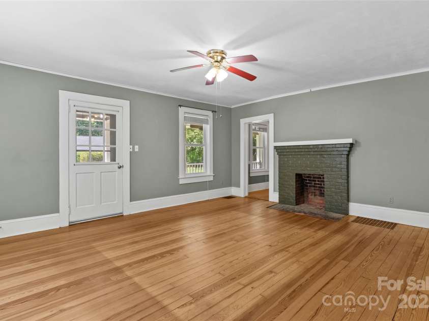 80 Laurel Avenue, Tryon, NC 28782.  MLS# CAR4299418, YatesRealty ID 1972. Living room with original fireplace and wood floors.