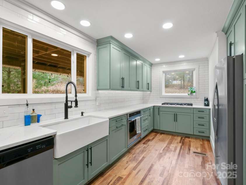 10 Bear Trail, Fairview, NC 28730.  MLS# CAR4232914, YatesRealty ID 19748. Gas range and farmhouse sink with large windows.