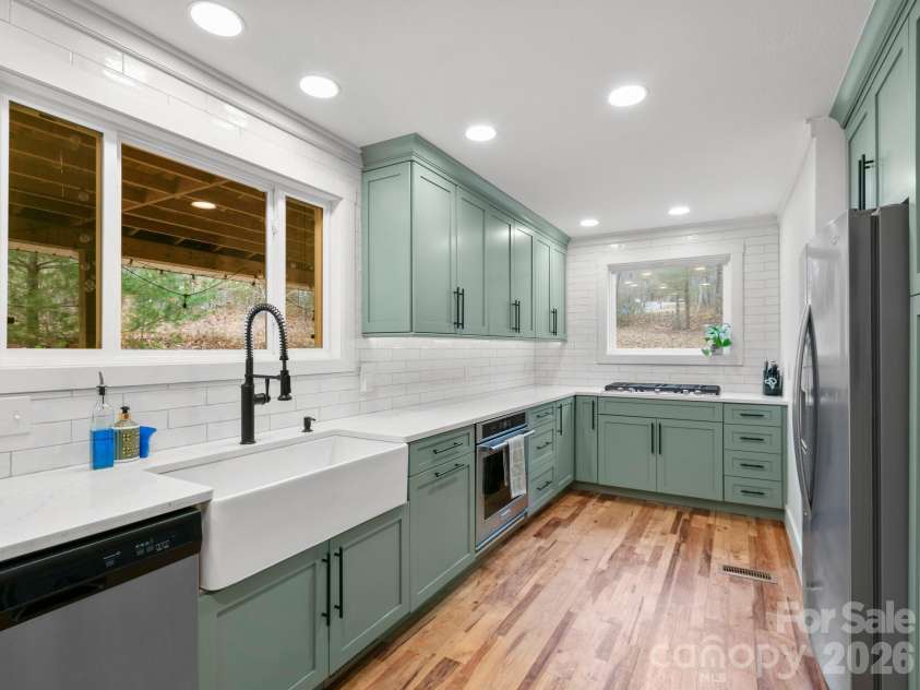 10 Bear Trail, Fairview, NC 28730.  MLS# CAR4232914, YatesRealty ID 19748. Gas range and farmhouse sink with large windows.