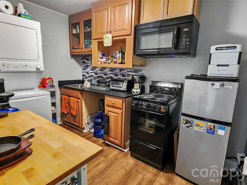8331 Dunstaff Road, Charlotte, NC 28269.  MLS# CAR4369538, YatesRealty ID 19771. Basement Full Kitchen with Refrigerator and Stove