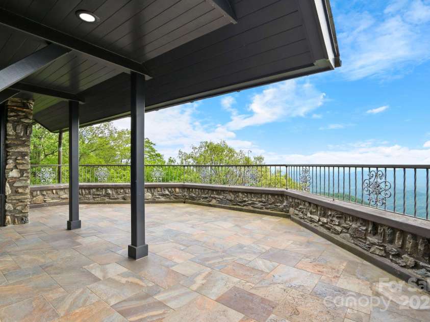 1245 Laurel Lane, Blowing Rock, NC 28605.  MLS# CAR4228582, YatesRealty ID 19780. One of multiple gorge-side stone patios on the back of the home....