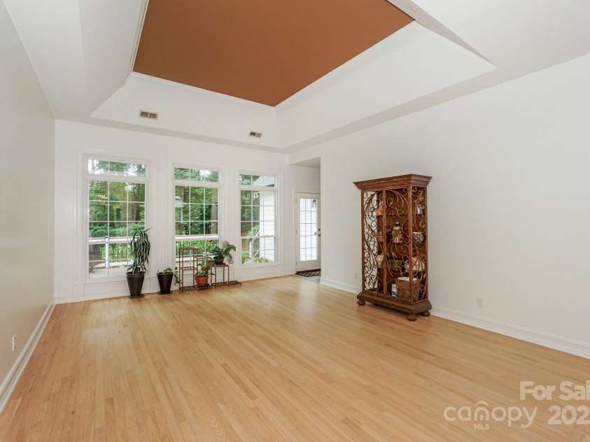 14831 Charterhouse Lane, Huntersville, NC 28078.  MLS# CAR4264707, YatesRealty ID 19794. Front Living Room showing newly refinished wood flooring, tray ceiling, and abundance of large windows with transoms