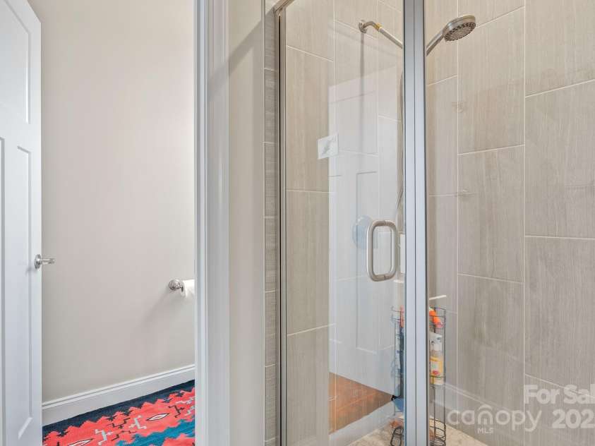 50 Rose Creek Road, Leicester, NC 28748.  MLS# CAR4228303, YatesRealty ID 19833. Walk-in tile shower and privacy toilet in primary