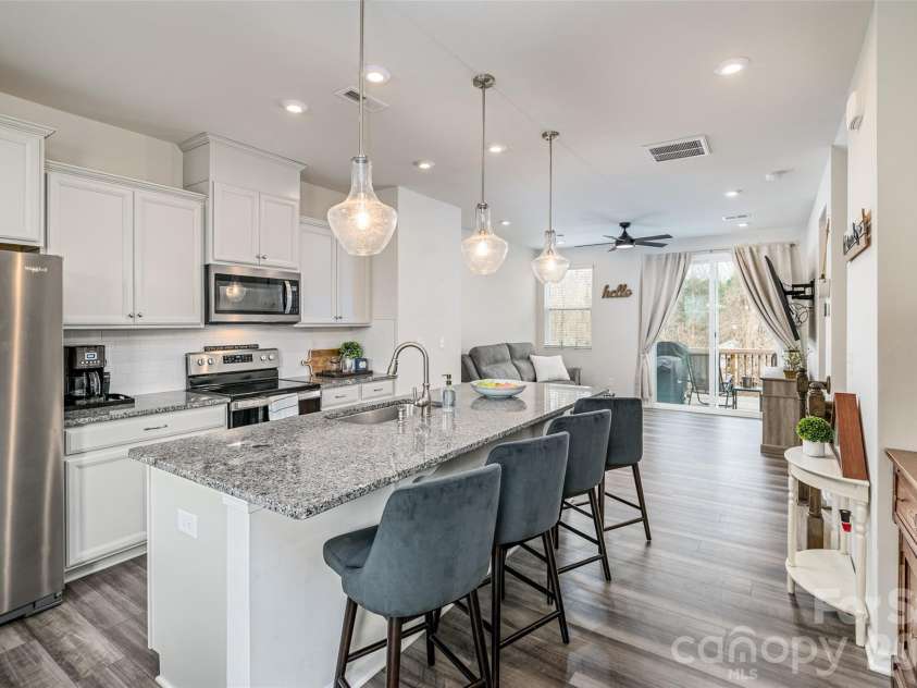 1206 Keydet Drive, Charlotte, NC 28216.  MLS# CAR4345736, YatesRealty ID 1984. Upgraded kitchen features granite counters, stainless steel appliances, tile back splash, spacious island with seating & storage, pantry & dining area on middle level floor.