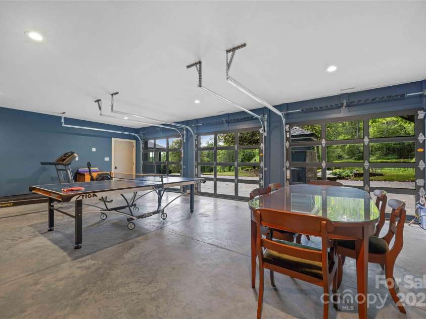 400 Kings Drive, Lake Lure, NC 28746.  MLS# CAR4264882, YatesRealty ID 19869. Utility room / gym  with finished concrete floor, HVAC, roll up garage doors, and plentiful sunshine.
