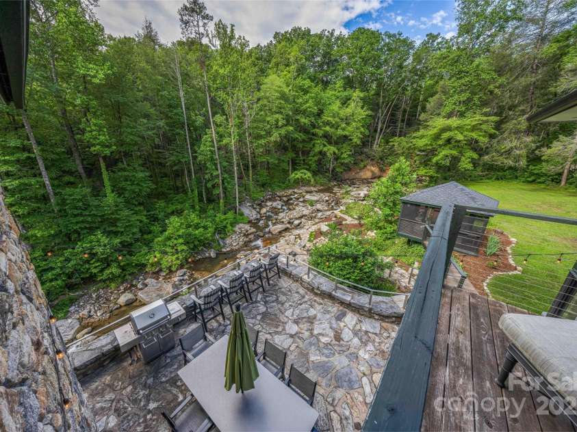 400 Kings Drive, Lake Lure, NC 28746.  MLS# CAR4329275, YatesRealty ID 19869. Second 2nd floor primary has forest view and private patio overlooking the bold flowing stream below. 