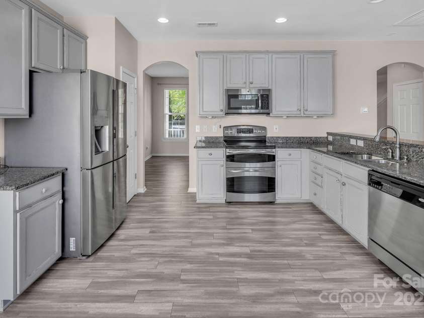 18023 Train Station Drive, Cornelius, NC 28031.  MLS# CAR4198417, YatesRealty ID 19875. Antiqued white cabinets, granite countertops and SS appliances make this kitchen a showstopper!