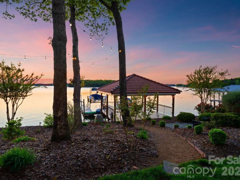 18103 Harbor Light Boulevard, Cornelius, NC 28031.  MLS# CAR4361515, YatesRealty ID 19890. Charming garden pathways wind through mature landscaping, guiding you effortlessly to the private dock and waterfront