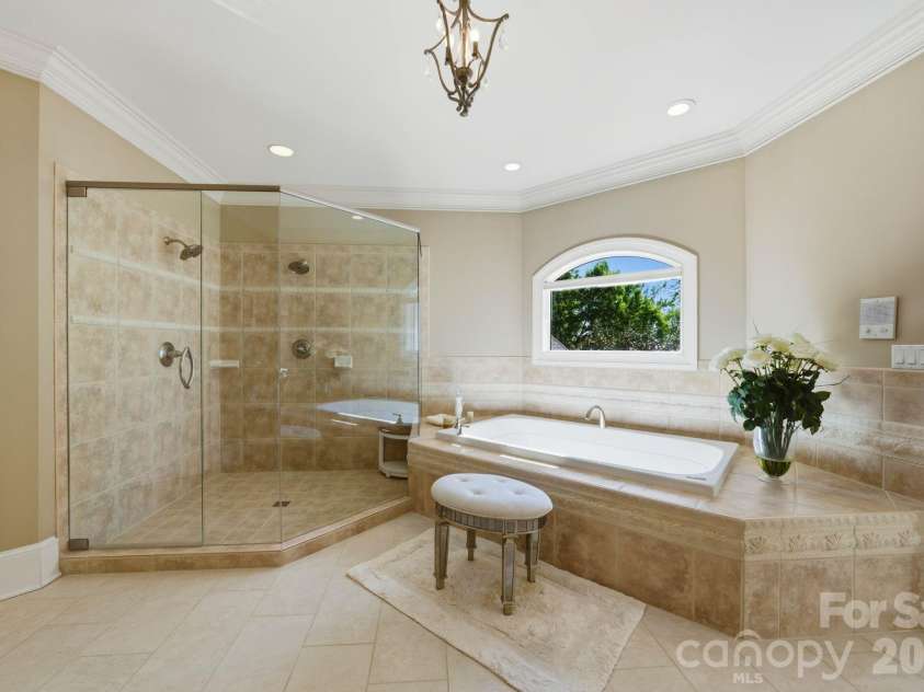 18103 Harbor Light Boulevard, Cornelius, NC 28031.  MLS# CAR4361515, YatesRealty ID 19890. Luxurious soaking tub and glass-enclosed shower create a serene, spa-like experience