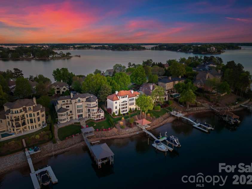 18103 Harbor Light Boulevard, Cornelius, NC 28031.  MLS# CAR4361515, YatesRealty ID 19890. Rear aerial highlighting the home’s expansive waterfront setting, private shoreline, and beautifully landscaped grounds