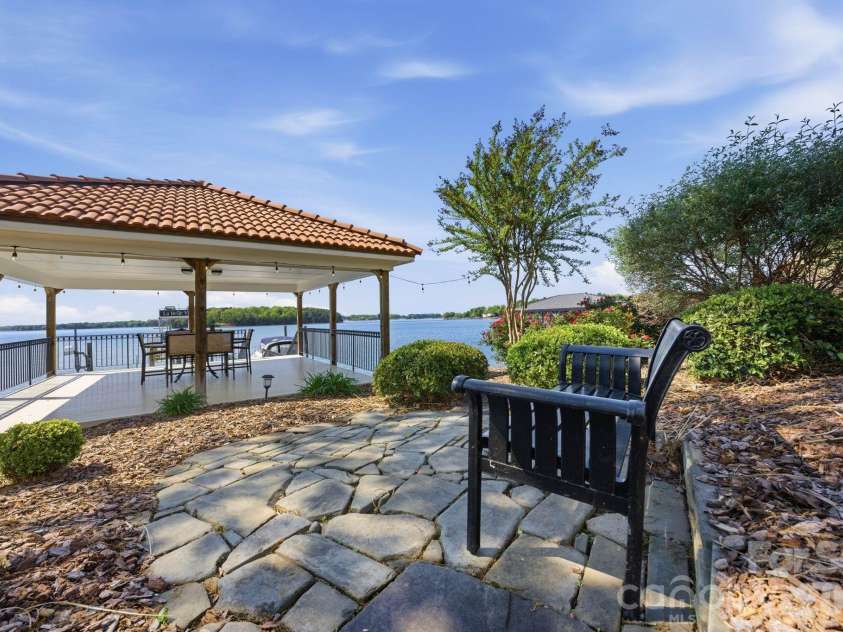 18103 Harbor Light Boulevard, Cornelius, NC 28031.  MLS# CAR4361515, YatesRealty ID 19890. Tranquil garden seating area surrounded by mature landscaping, creating a peaceful retreat moments from the covered lakeside pavilion and water’s edge