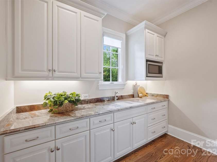 3032 Kings Manor Drive, Matthews, NC 28104.  MLS# CAR4265351, YatesRealty ID 19894. Just off the kitchen is a rare scullery kitchen, with a sink, custom cabinets, and permanent wooden shelves.