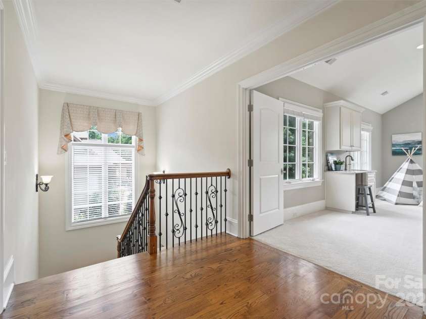 3032 Kings Manor Drive, Matthews, NC 28104.  MLS# CAR4265351, YatesRealty ID 19894. The landing upstairs features hardwood flooring and wrought iron balusters.