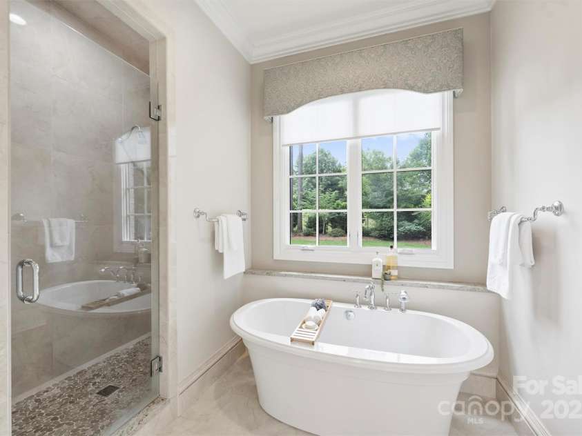 3032 Kings Manor Drive, Matthews, NC 28104.  MLS# CAR4265351, YatesRealty ID 19894. This bathroom features nice architectural details such as a barreled ceiling, and an over-sized shower with river rock flooring.