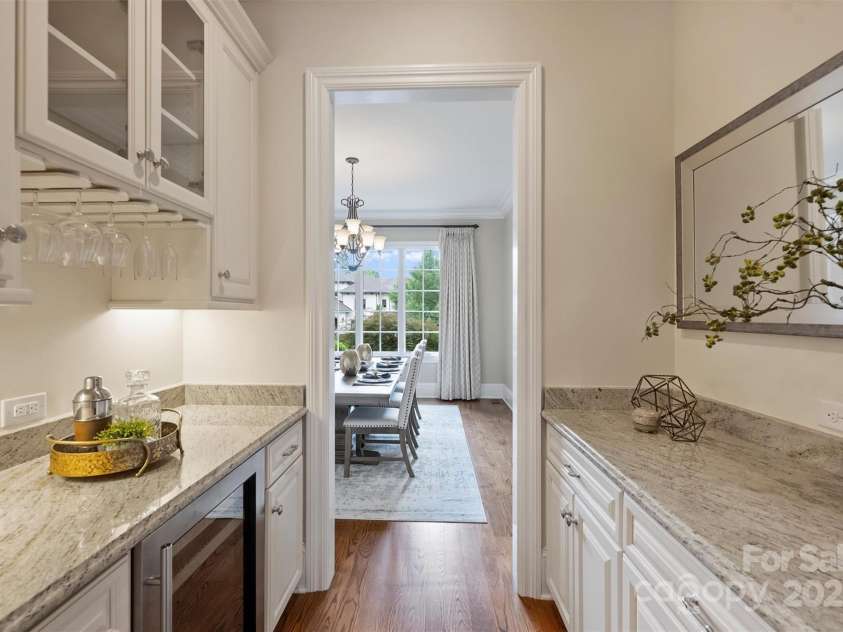 3032 Kings Manor Drive, Matthews, NC 28104.  MLS# CAR4265351, YatesRealty ID 19894. This convenient bar area features Eudy's cabinetry and beautiful granite countertops.  The wine fridge conveys with the home, sold as-is.
