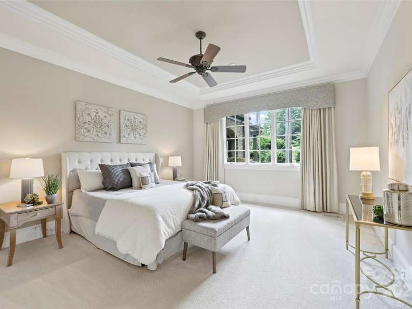 3032 Kings Manor Drive, Matthews, NC 28104.  MLS# CAR4265351, YatesRealty ID 19894. This peaceful and inviting primary bedroom boasts a tray ceiling and large window overlooking the backyard.