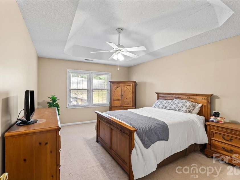 14413 John Beck Drive, Charlotte, NC 28273.  MLS# CAR4374623, YatesRealty ID 19941. Spacious primary bedroom with tray ceiling, freshly painted in 2026, set privately on its own side of the home