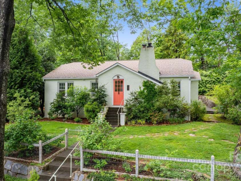 160 Hidden Hill Road, Tryon, NC 28782.  MLS# CAR4259798, YatesRealty ID 19956. Stone walls and terraced gardens surround the home. Separate brick garage hidden behind the house.