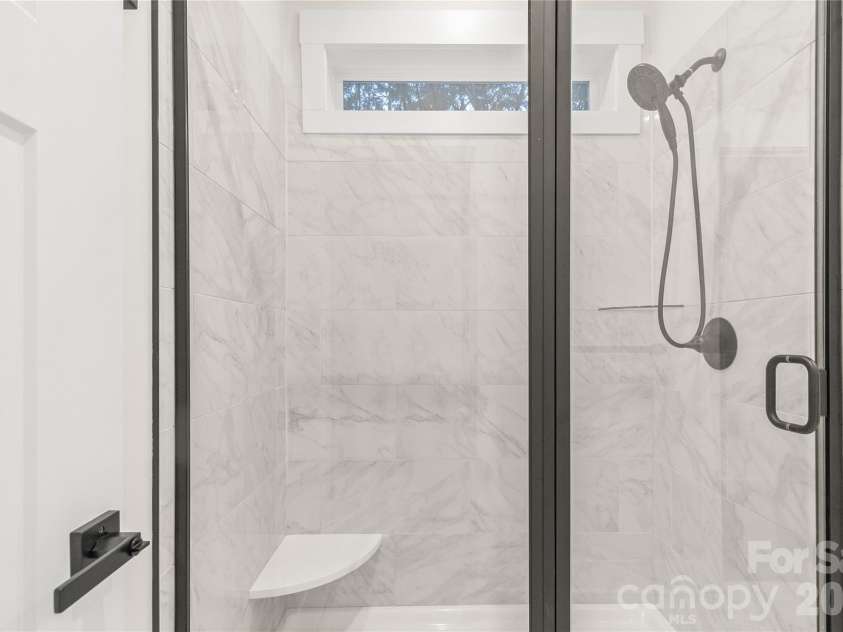 2589 Polo Lane, Maiden, NC 28650.  MLS# CAR4370172, YatesRealty ID 19979. Primary shower with porcelain tile. Bench for the ladies for shaving. Window for added natural light