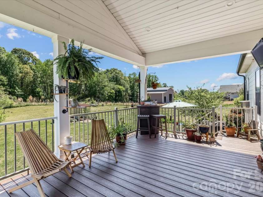 355 Cal Kennedy Road, Cleveland, NC 27013.  MLS# CAR4371840, YatesRealty ID 19980. Covered back porch/deck elevated above the expansive backyard looks out toward your fire pit, garden, greenhouse and chicken/duck coop (coop conveys if buyer wants it)