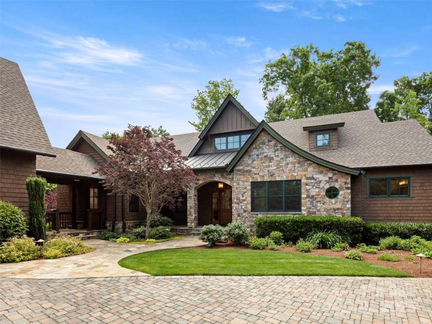 24 Deep Creek Trail, Arden, NC 28704.  MLS# CAR4264318, YatesRealty ID 20015. Glennwood Builders custom 4 bedroom 4 1/2 bath home with beautiful stone-faced and shingled cottage design. Covered breezeway connects garage to main house and provides access to rear yard.