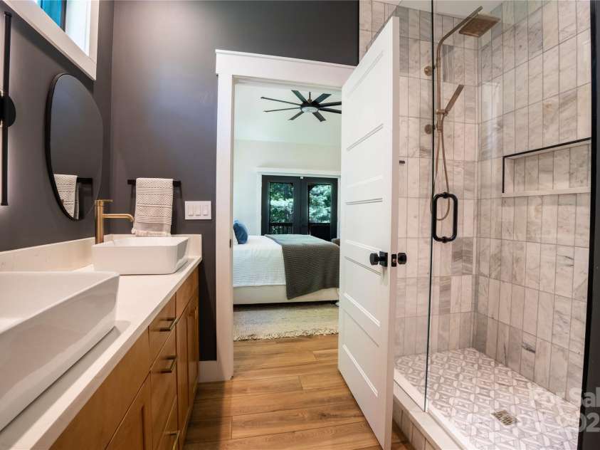 13 Cambridge Drive, Candler, NC 28715.  MLS# CAR4249606, YatesRealty ID 20021. Spa-inspired ensuite features a luxurious tiled shower, double vanity with quartz countertops