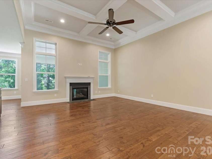 7304 Sedgebrook Drive, Stanley, NC 28164.  MLS# CAR4372754, YatesRealty ID 20028. A second look at the living room reveals what the windows have been framing all along — a private backyard and screened porch that feel like a natural extension of the space.