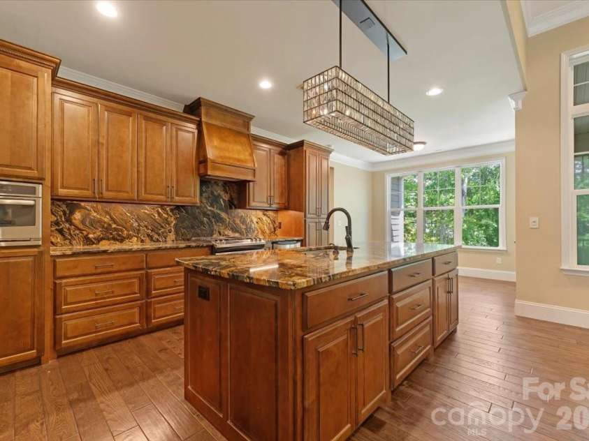 7304 Sedgebrook Drive, Stanley, NC 28164.  MLS# CAR4372754, YatesRealty ID 20028. The details are in the continuity — granite countertops and a seamless backsplash that make this kitchen feel custom from every angle.