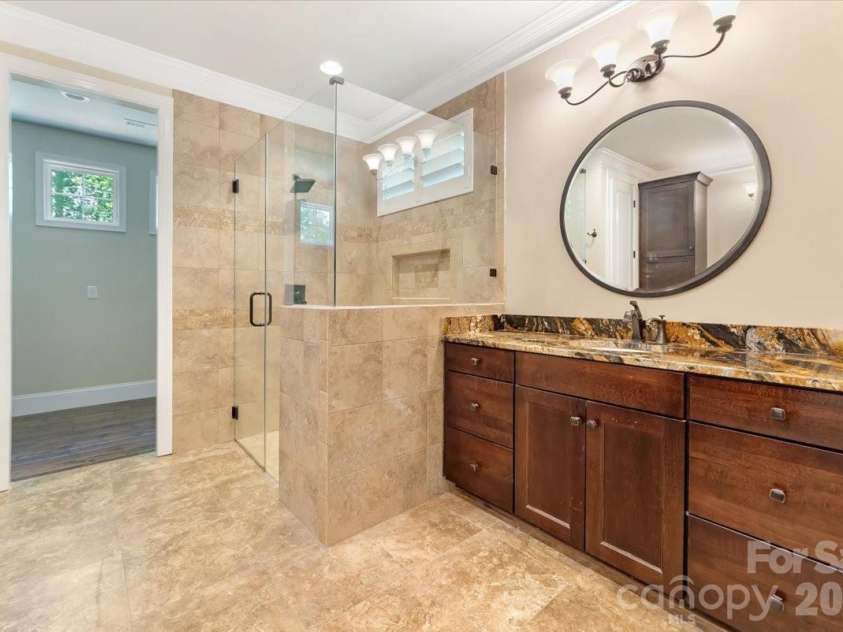 7304 Sedgebrook Drive, Stanley, NC 28164.  MLS# CAR4372754, YatesRealty ID 20028. Tile flooring, a frameless glass shower, and a zero-entry design that makes stepping in feel like stepping into a boutique hotel — every single morning.