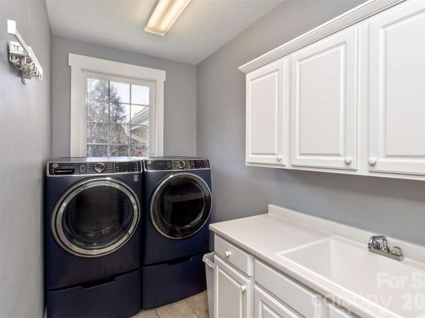 37 Creekside View Drive, Asheville, NC 28804.  MLS# CAR4361134, YatesRealty ID 20063. Main level laundry room with sink off kitchen