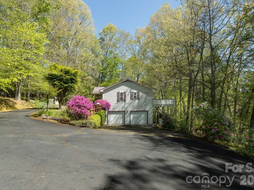 304 Emerald Hills Drive, Pisgah Forest, NC 28768.  MLS# CAR4373958, YatesRealty ID 20076. Driveway & Garage Approach – Generous driveway provides easy access and additional parking, with a peaceful wooded setting surrounding the property.