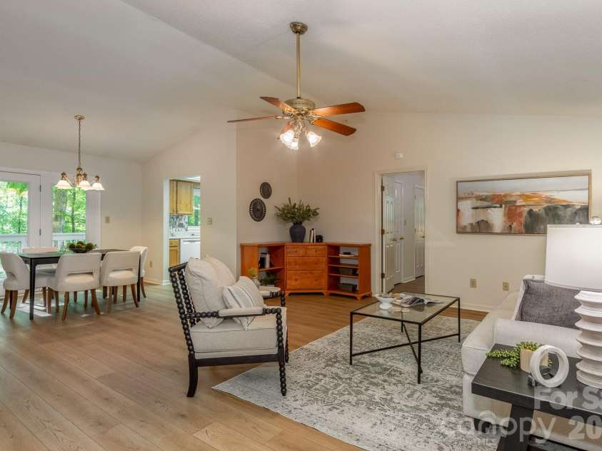 304 Emerald Hills Drive, Pisgah Forest, NC 28768.  MLS# CAR4373958, YatesRealty ID 20076. Living & Dining Area – Spacious open-concept living and dining area with updated flooring, vaulted ceilings, and an easy flow for everyday living and entertaining. Large glass doors bring in natural light and p