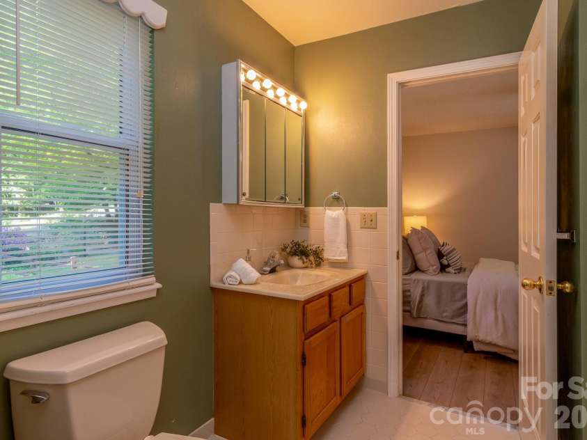 304 Emerald Hills Drive, Pisgah Forest, NC 28768.  MLS# CAR4373958, YatesRealty ID 20076. Primary Bathroom – Primary bathroom with vanity storage, natural light, and convenient access from the bedroom. Clean, functional layout ready for everyday use.