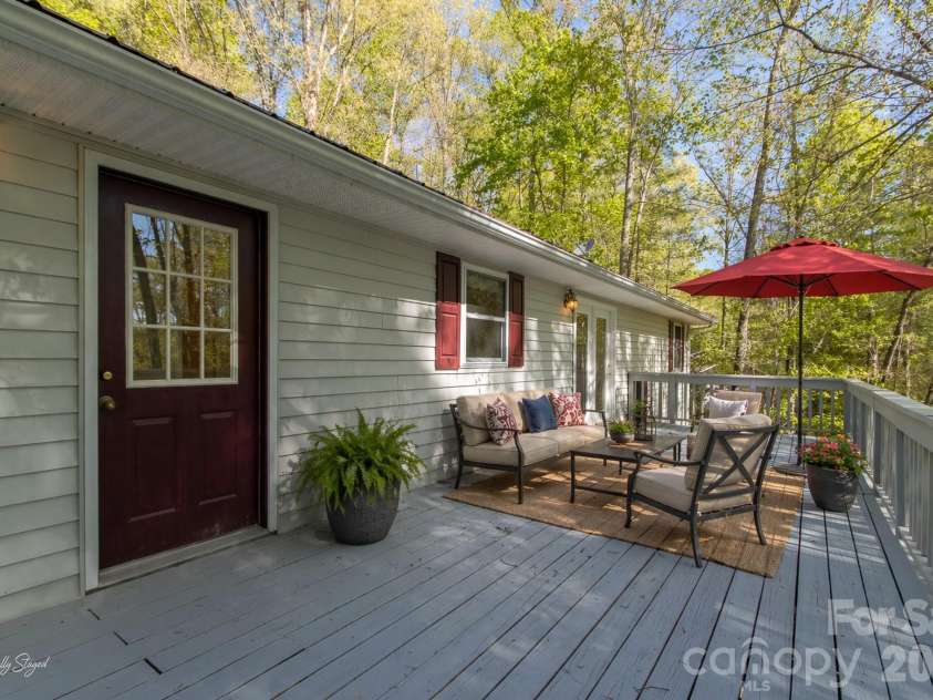 304 Emerald Hills Drive, Pisgah Forest, NC 28768.  MLS# CAR4373958, YatesRealty ID 20076. Rear Deck (Alternate Angle) – Generous deck layout extends the living space outdoors, with easy access from the home and room for dining or gathering. virtually staged