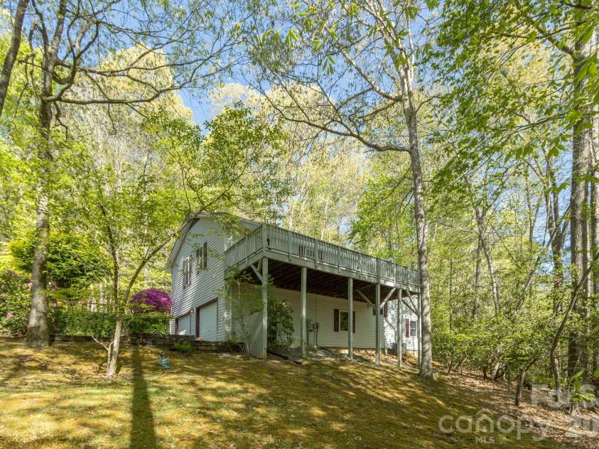 304 Emerald Hills Drive, Pisgah Forest, NC 28768.  MLS# CAR4373958, YatesRealty ID 20076. Rear/Under Deck View – Covered area beneath the deck provides additional sheltered outdoor space and highlights the home’s elevated position on the lot.