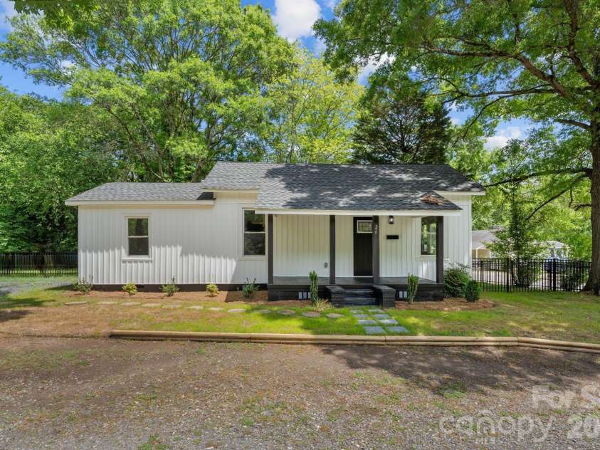 26 Poe Street, Rock Hill, SC 29730.  MLS# CAR4377637, YatesRealty ID 20117. This beautifully renovated modern farmhouse cottage features crisp white vinyl siding perfectly accented by bold black trim and a charming recessed front porch. The high-contrast aesthetic creates a striking curb appeal, nes