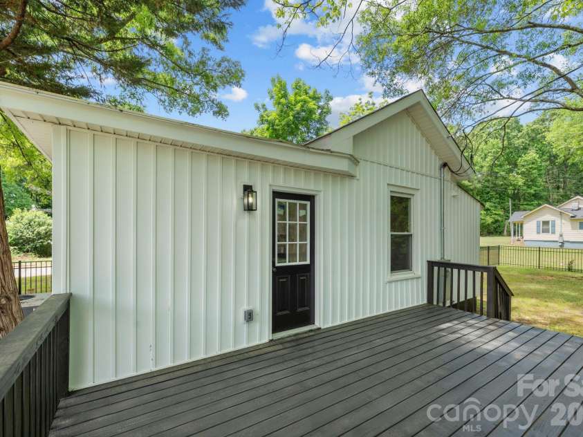 26 Poe Street, Rock Hill, SC 29730.  MLS# CAR4377637, YatesRealty ID 20117. This spacious rear deck offers the perfect setting for outdoor dining and entertaining, featuring a sleek dark finish that overlooks the large fenced-in yard. Privately nestled under mature trees, the deck provides a seamles