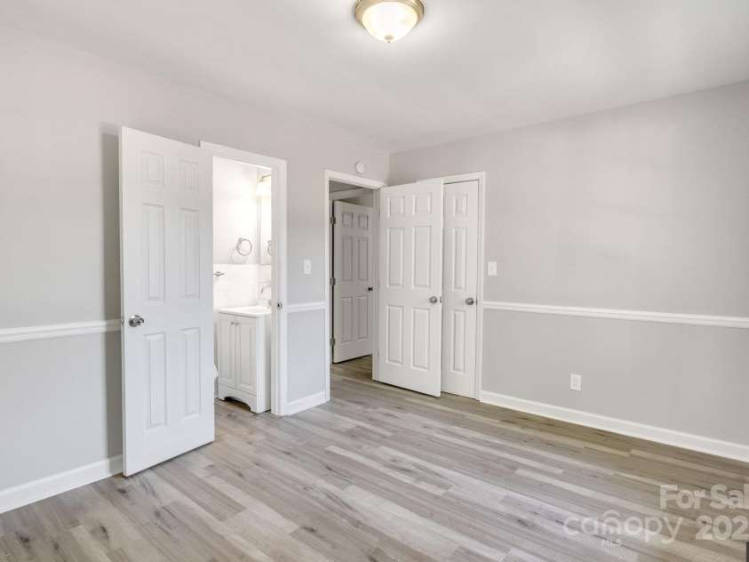 3637 Glenville Avenue, Charlotte, NC 28215.  MLS# CAR4257290, YatesRealty ID 20152. Second shot of primary bedroom, showing entry door to half bath on left, and entry door open on right.
