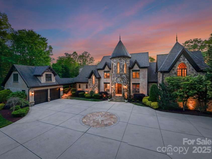 172 Tennessee Circle, Mooresville, NC 28117.  MLS# CAR4252701, YatesRealty ID 20154. Pass through a private gate to arrive at this grand stone residence, where a nautical star design anchors the front driveway. A stately façade with arched entry and manicured landscaping warmly welcomes you home.