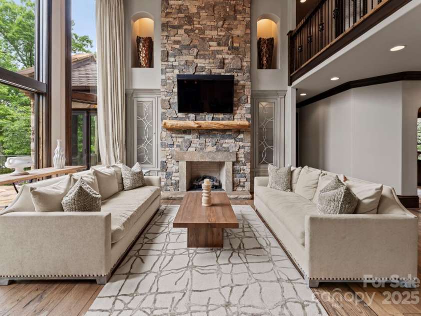 172 Tennessee Circle, Mooresville, NC 28117.  MLS# CAR4252701, YatesRealty ID 20154. Two-story living room with fireplace, chandelier, and custom cabinetry.