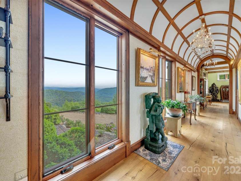 278 Snow Ridge Drive, Hendersonville, NC 28792.  MLS# CAR4221130, YatesRealty ID 20164. A standout feature of this home is the custom, barrel vault gallery with antique chandeliers, leading from the entry to the main living room with incredible northern mountain views.