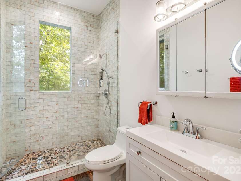 265 Laurel Branch Road, Canton, NC 28716.  MLS# CAR4231718, YatesRealty ID 2017. Very spacious bathroom features a shower window with views of the forest and river!