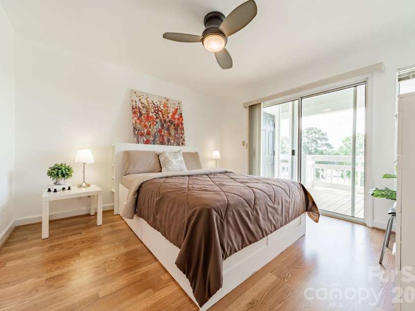 17919 Kings Point Drive, Cornelius, NC 28031.  MLS# CAR4372495, YatesRealty ID 20233. Primary bedroom is a generous size.  Plus it provides direct access to the beautiful deck and the gorgeous views.